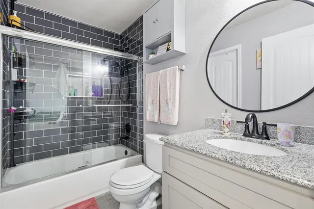 a bathroom with a granite countertop sink toilet and shower