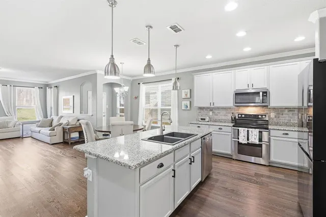 a open kitchen with stainless steel appliances granite countertop a stove and a sink