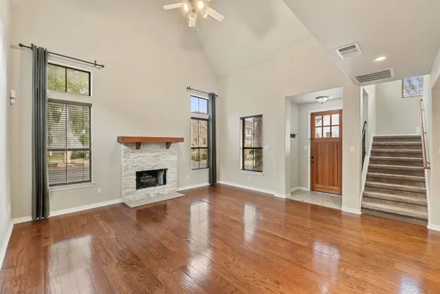 a view of a livingroom with a fireplace a chandelier and windows