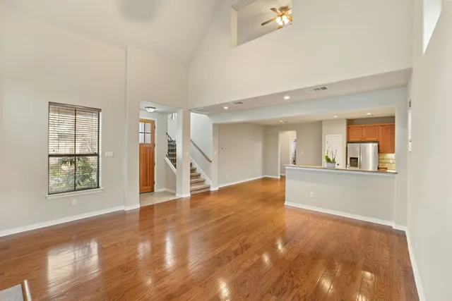 a view of a livingroom with a fireplace wooden floor and windows