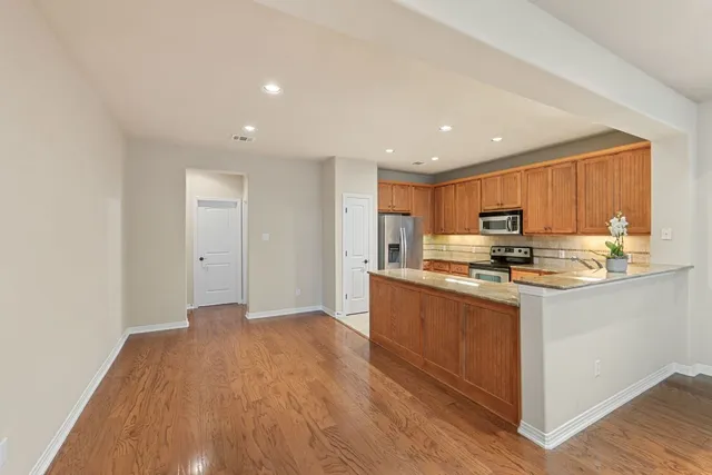 a view of kitchen and hall with wooden floor