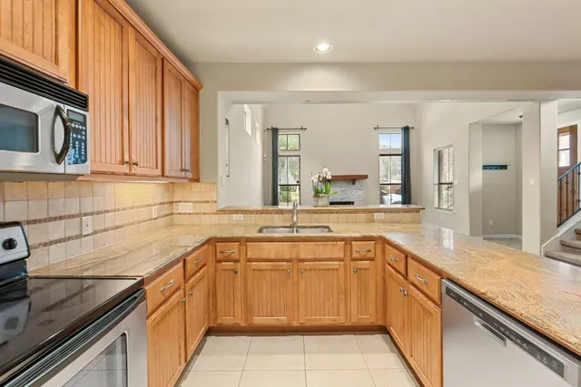 a kitchen with stainless steel appliances granite countertop a sink stove and refrigerator