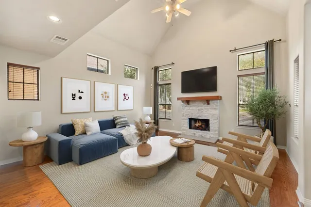 a living room with furniture a flat screen tv and a fireplace
