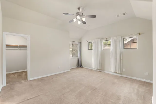 an empty room with a ceiling fan and a window