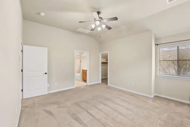 an empty room with fan and windows