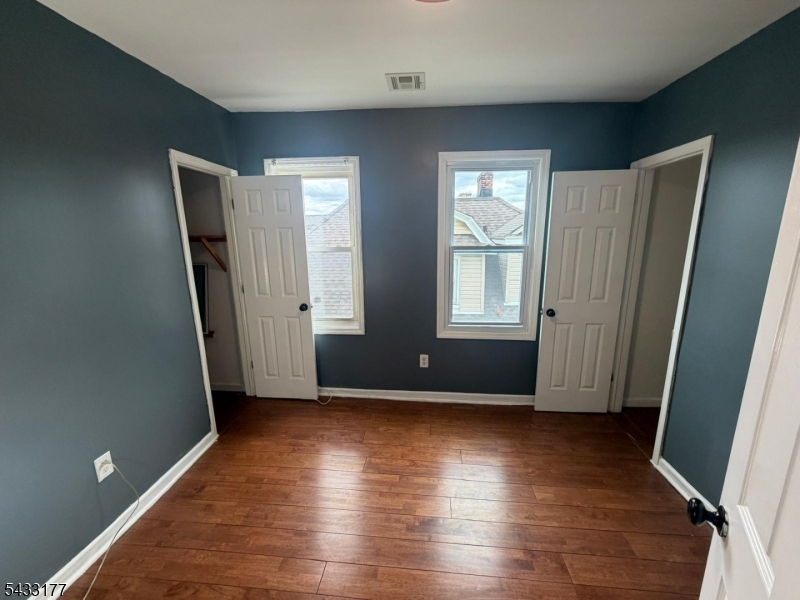 166 Renner Avenue, Unit 3 Newark, NJ 07112 - Photo 19 of 24 an empty room with wooden floor and windows