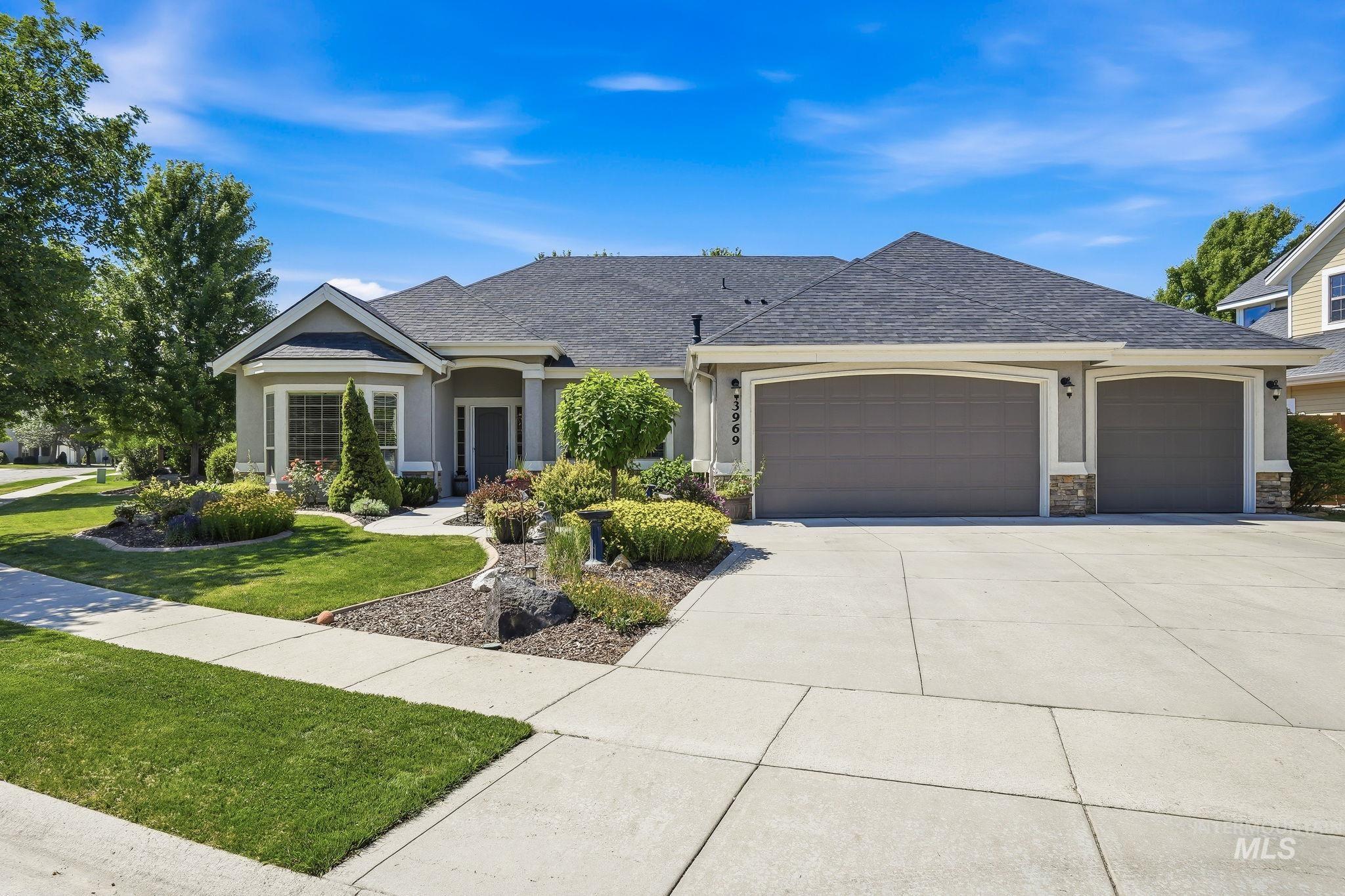 3969 North Hollymount Way Meridian, ID 83646 - Photo 1 of 47 Single-story residence featuring a gray exterior with stone accents, a multi-car garage, and a concrete driveway
