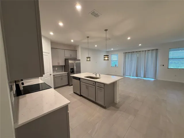 a large kitchen with a large counter top appliances and cabinets