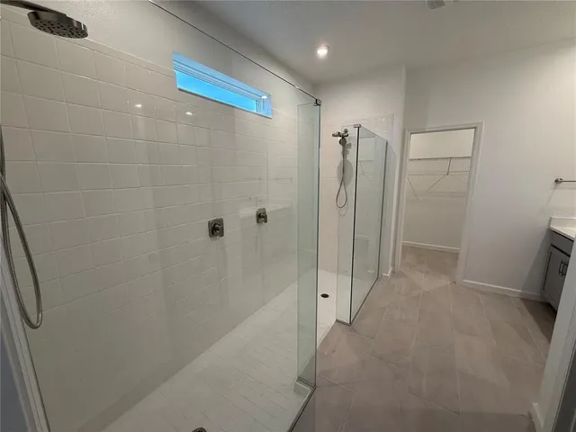 a bathroom with a shower and a glass door