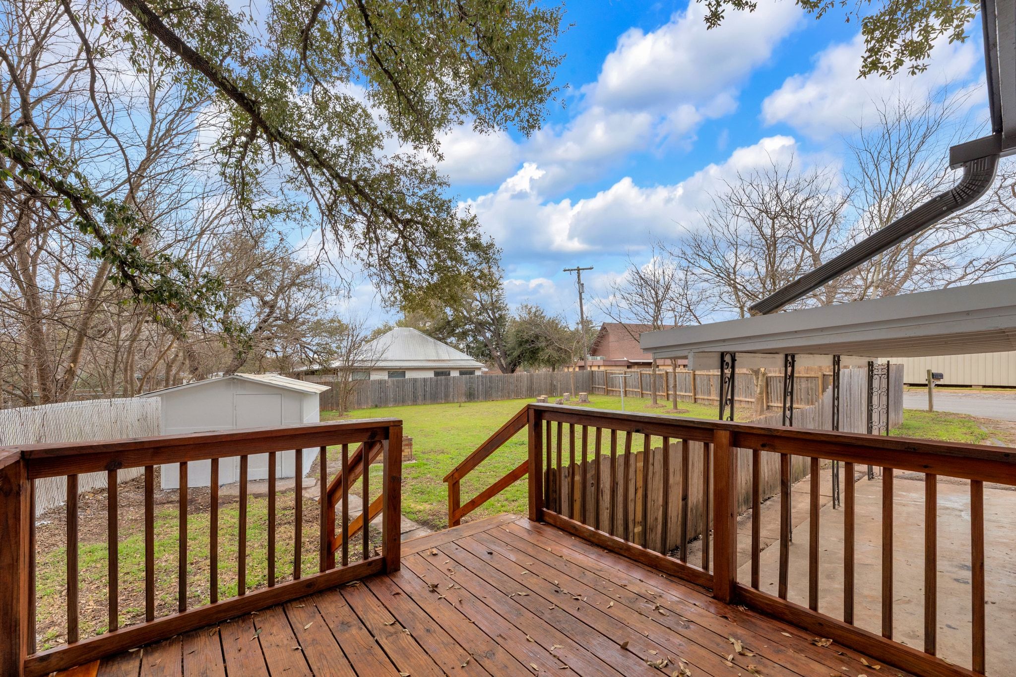 1709 Cecelia Street Taylor, TX 76574 - Photo 34 of 37 Deck with a fenced backyard and a storage shed