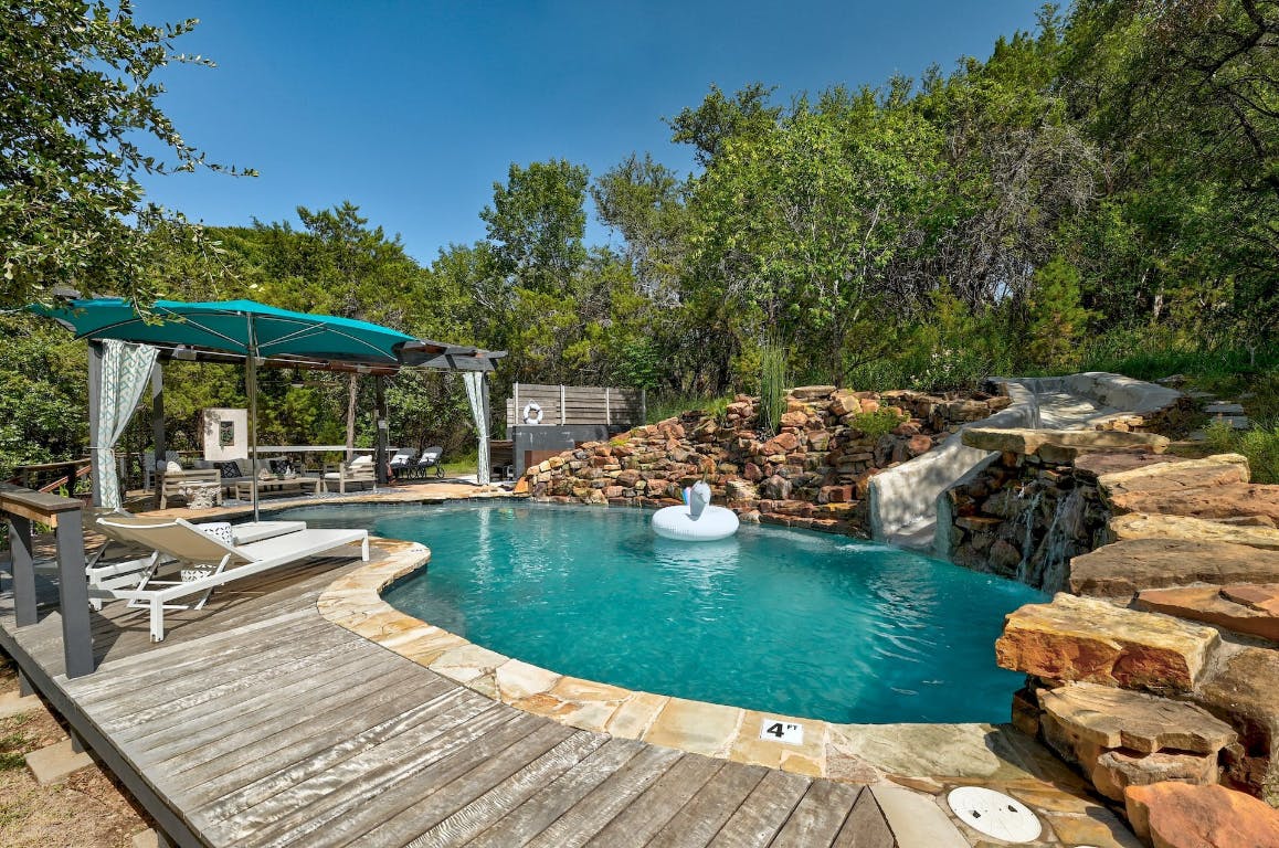 2001 Mestena Trail Austin, TX 78733 - Photo 2 of 40 a view of a swimming pool and lounge chairs in patio