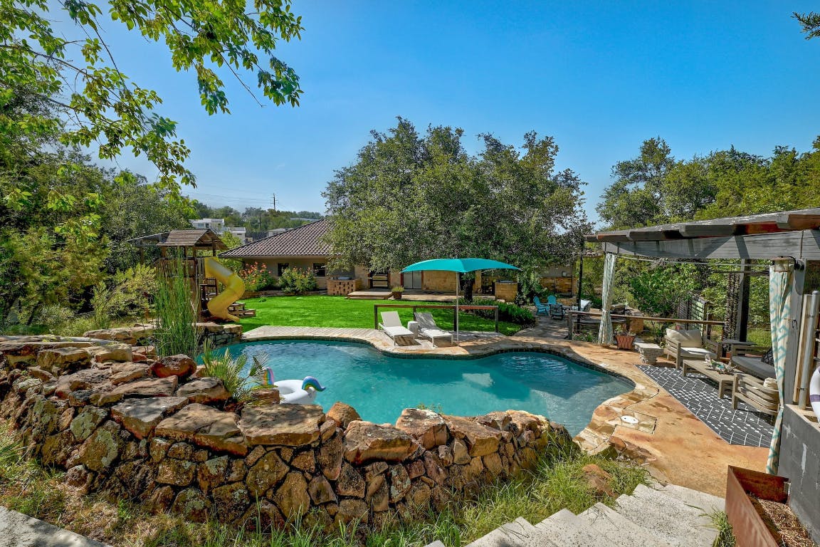 2001 Mestena Trail Austin, TX 78733 - Photo 40 of 40 a view of a swimming pool with a patio and a garden