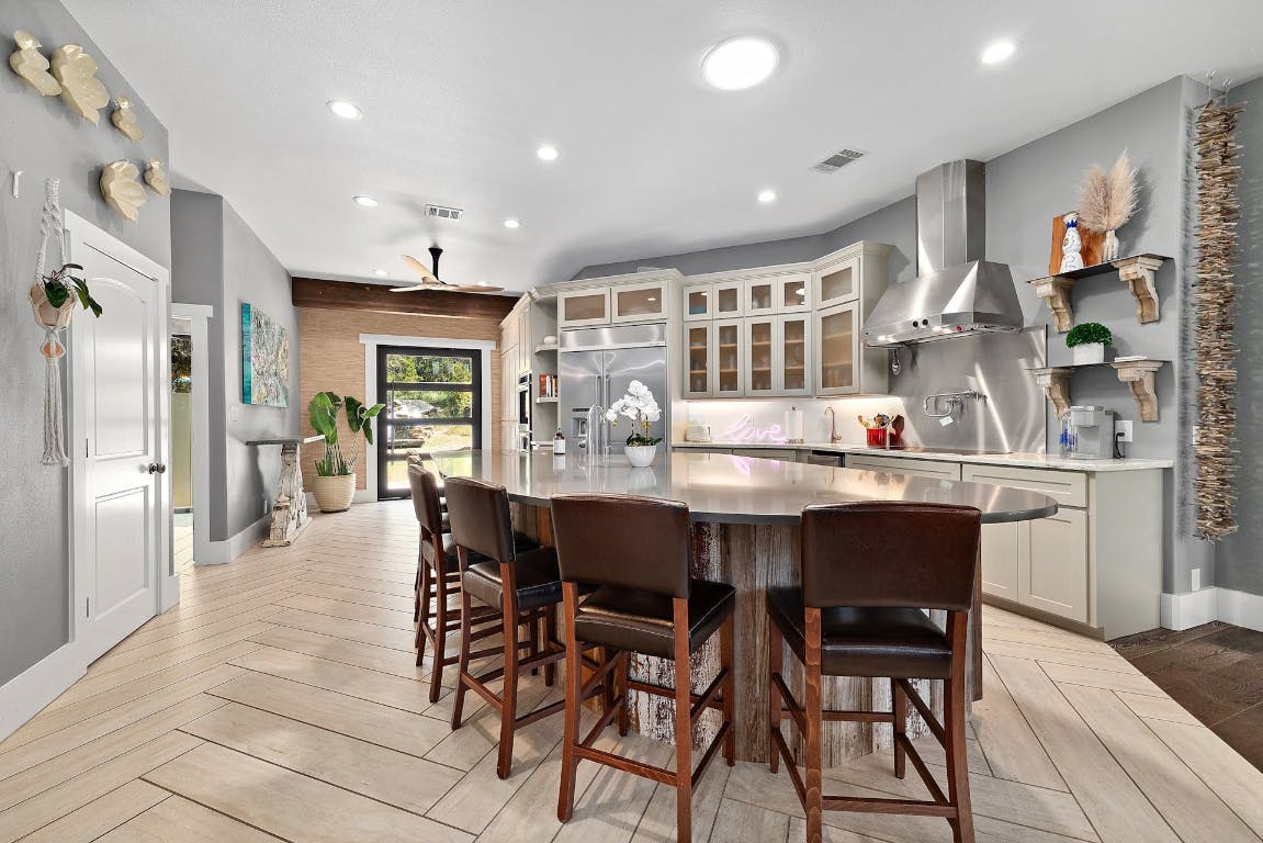 2001 Mestena Trail Austin, TX 78733 - Photo 6 of 40 a dining room with stainless steel appliances kitchen island granite countertop a dining table chairs and refrigerator