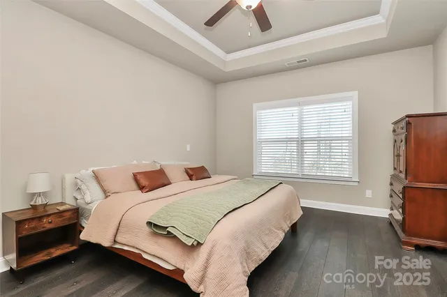 a bedroom with a bed flat screen tv and a large window