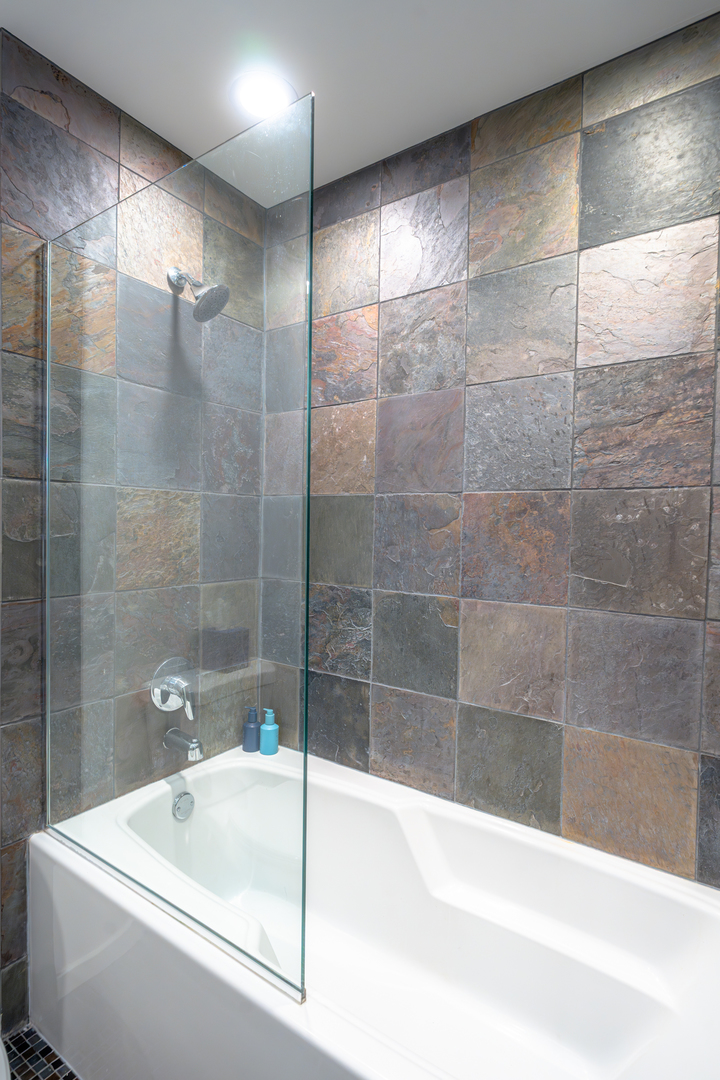 240 East Illinois Street, Unit 1606 Chicago, IL 60611 - Photo 15 of 22 a white bath tub sitting next to a white sink and a shower