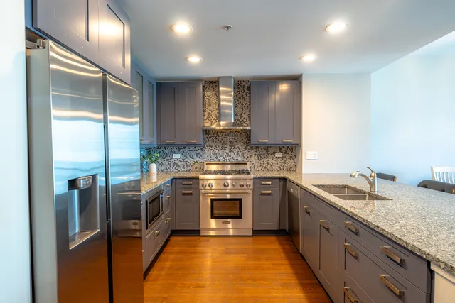 a kitchen with stainless steel appliances granite countertop a sink stove and refrigerator