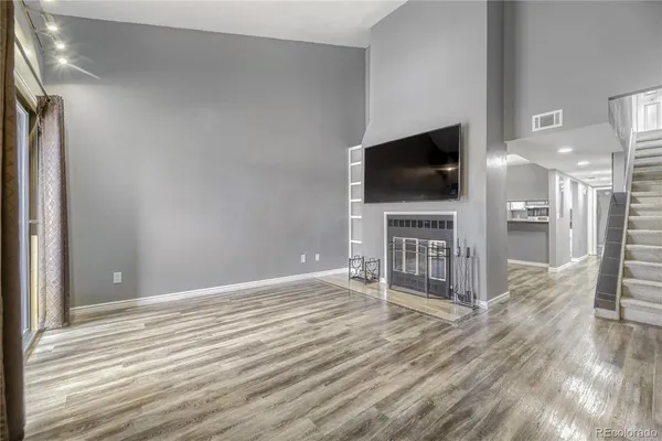 a view of a livingroom with wooden floor and a flat screen tv