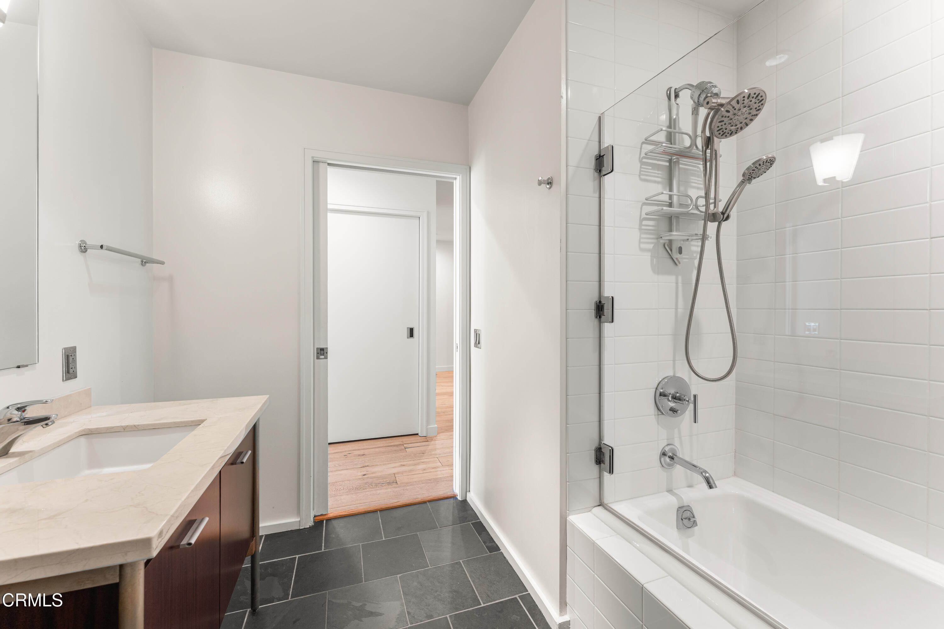 1155 South Grand Avenue, Unit 2106 Los Angeles, CA 90015 - Photo 32 of 51 a bathroom with a granite countertop sink a shower and a mirror