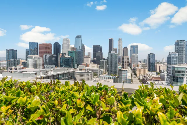 a view of a patio with couches table and chairs under an umbrella with a fire pit