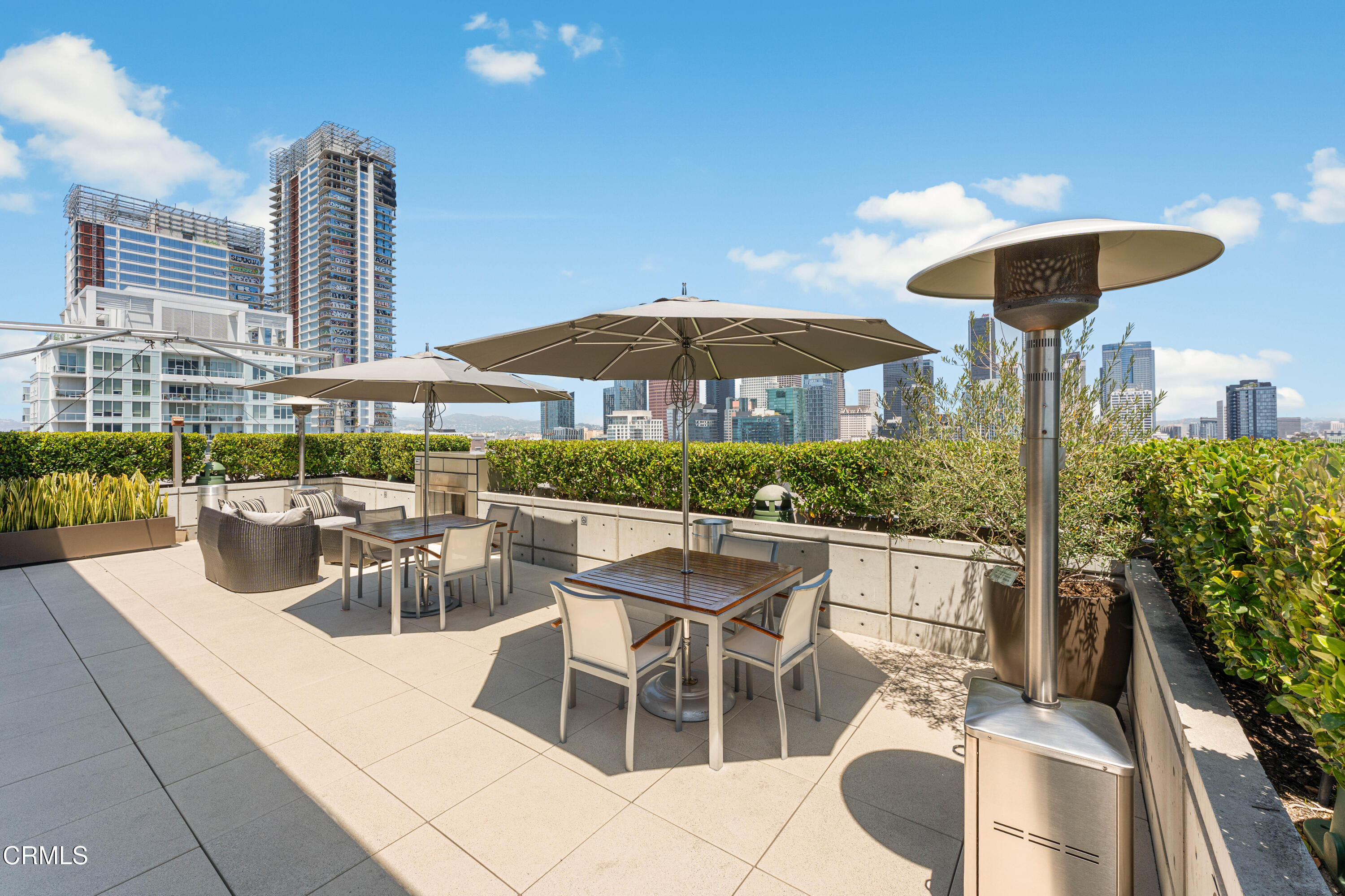 1155 South Grand Avenue, Unit 2106 Los Angeles, CA 90015 - Photo 43 of 51 a view of a patio with couches table and chairs under an umbrella with a fire pit
