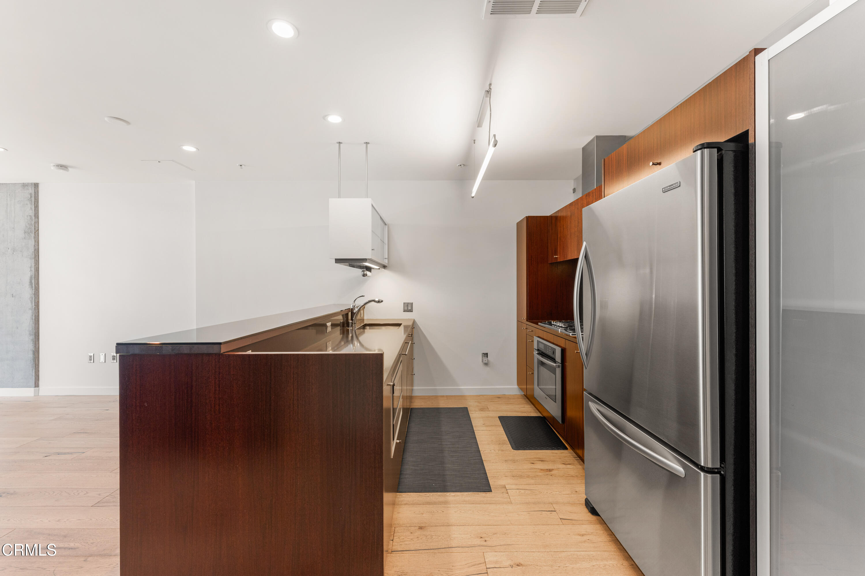 1155 South Grand Avenue, Unit 2106 Los Angeles, CA 90015 - Photo 10 of 51 a view of a refrigerator in kitchen and an empty room