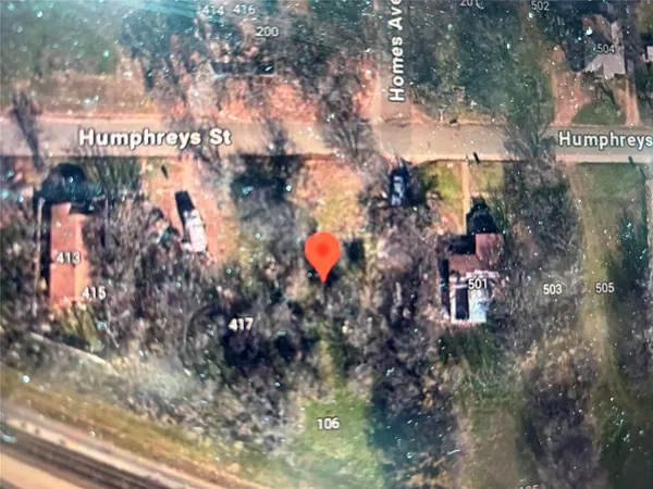 a sign that is sitting in front of the tree