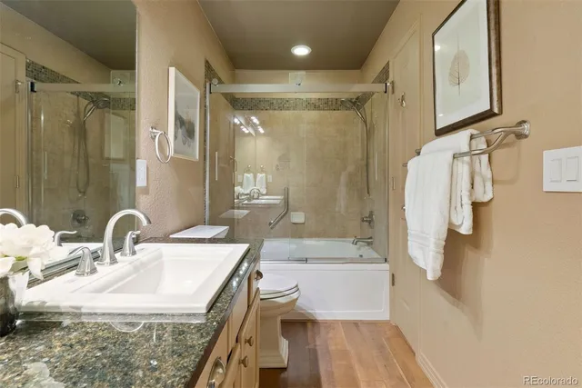 a bathroom with a granite countertop sink a shower and a mirror