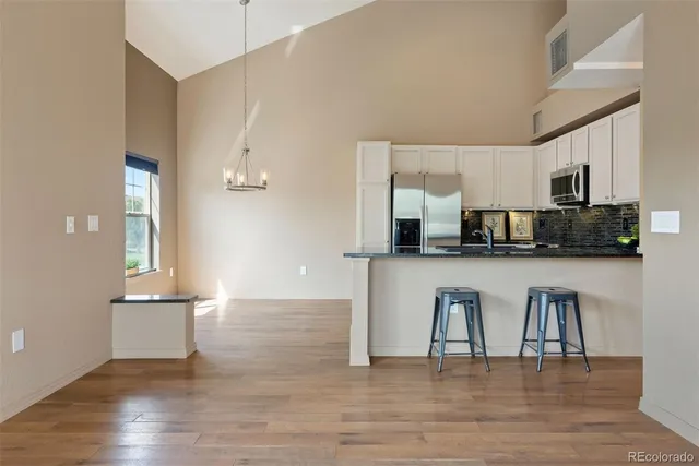 a open kitchen with white cabinets and stainless steel appliances