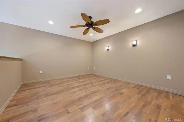 an empty room with window and ceiling fan