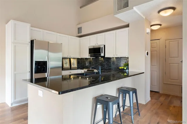 a kitchen with kitchen island a counter top space cabinets and stainless steel appliances