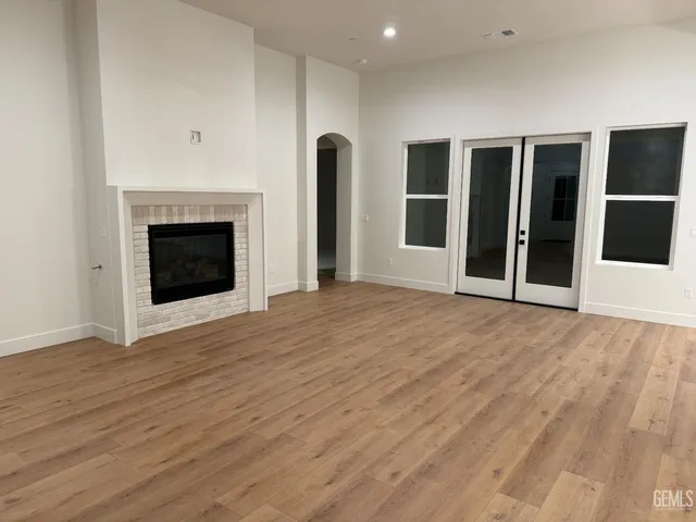 a view of an empty room with a fireplace and a window