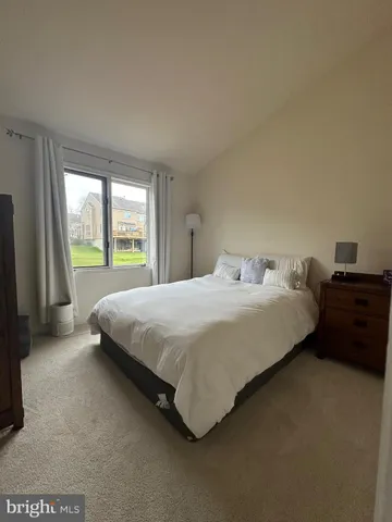 a large bed sitting in a bedroom next to a window