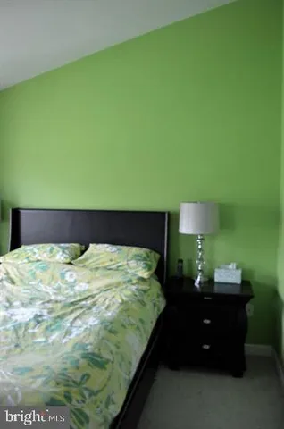 a bed sitting in a bedroom next to a lamp