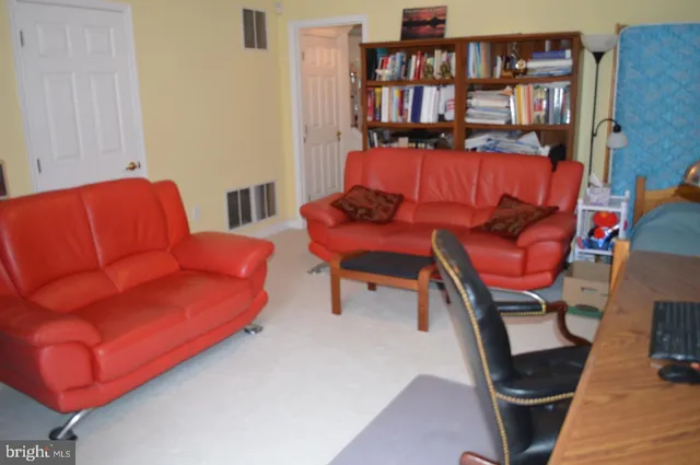 a living room with furniture and a book shelf