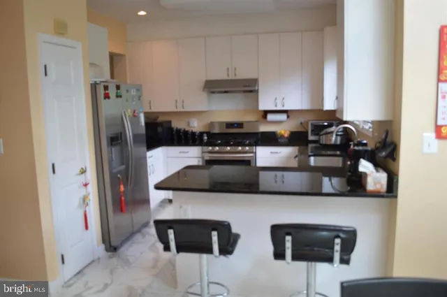 a kitchen with stainless steel appliances granite countertop a stove and a refrigerator