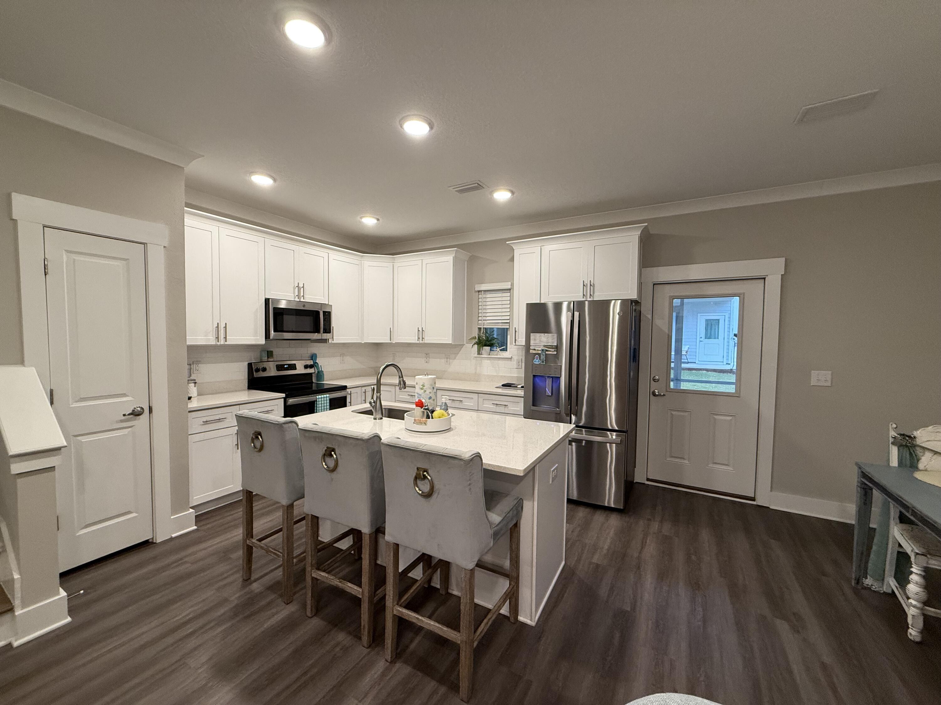 406 Date Palm Lane Freeport, FL 32439 - Photo 11 of 44 a kitchen with refrigerator a sink a stove a refrigerator cabinets and wooden floor