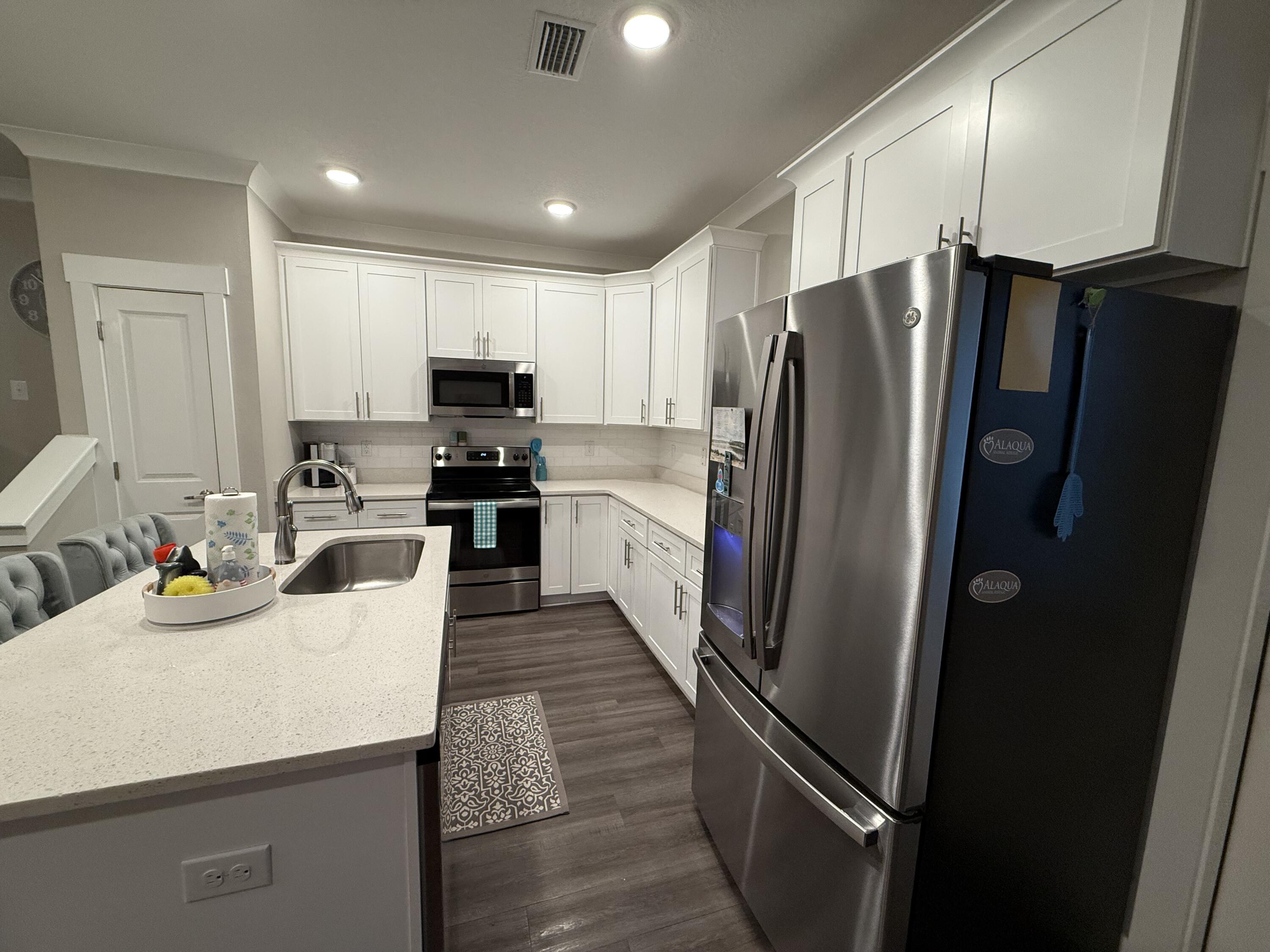 406 Date Palm Lane Freeport, FL 32439 - Photo 14 of 44 a kitchen with stainless steel appliances a refrigerator and a stove top oven