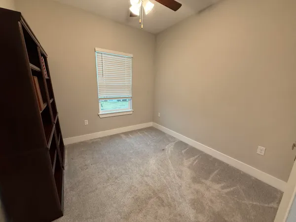 an empty room with chandelier fan