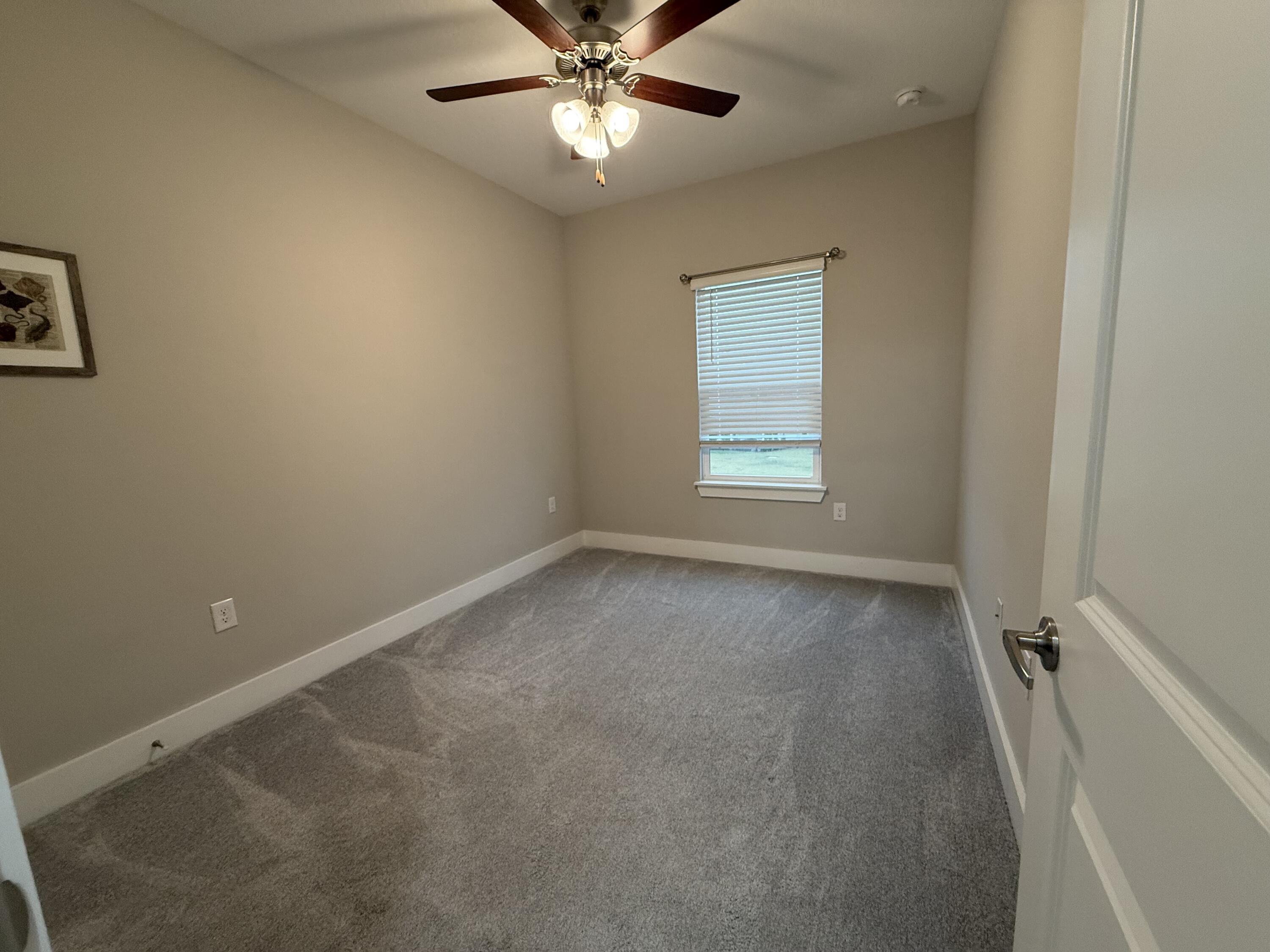 406 Date Palm Lane Freeport, FL 32439 - Photo 29 of 44 an empty room with a window and a fan
