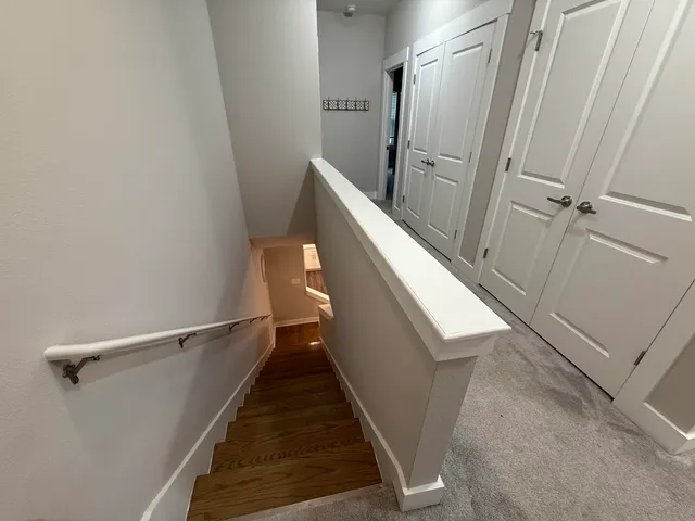 a view of a white house with large windows and a yard