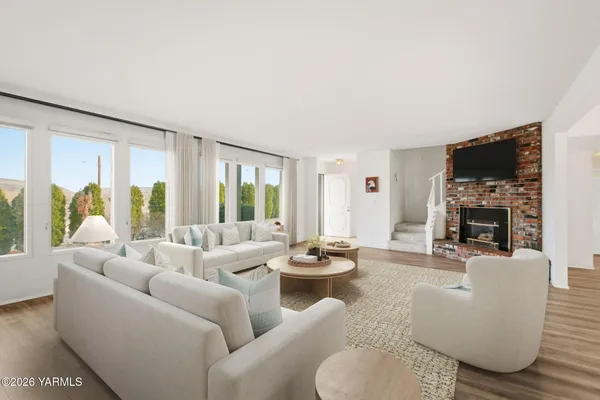 a living room with furniture fireplace and a large window