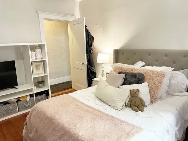 a large bedroom with a bed and a flat screen tv