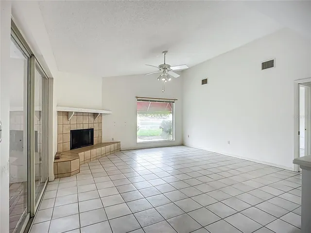 an empty room with windows and fireplace
