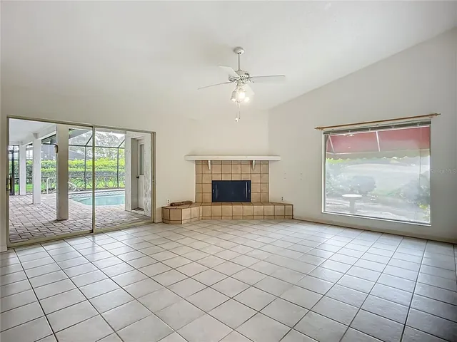 a view of an empty room with glass door and a fireplace