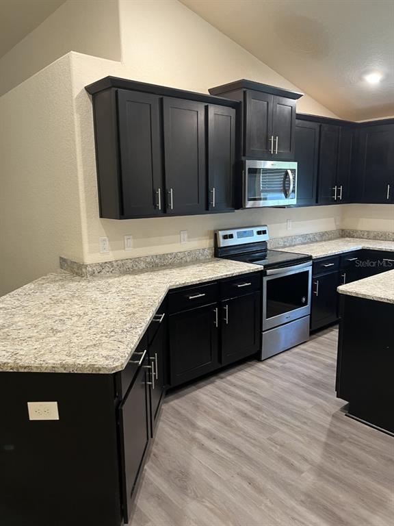 10 Diamond Ridge Way Ocala, FL 34472 - Photo 7 of 13 a kitchen with stainless steel appliances granite countertop wooden cabinets a refrigerator and a stove