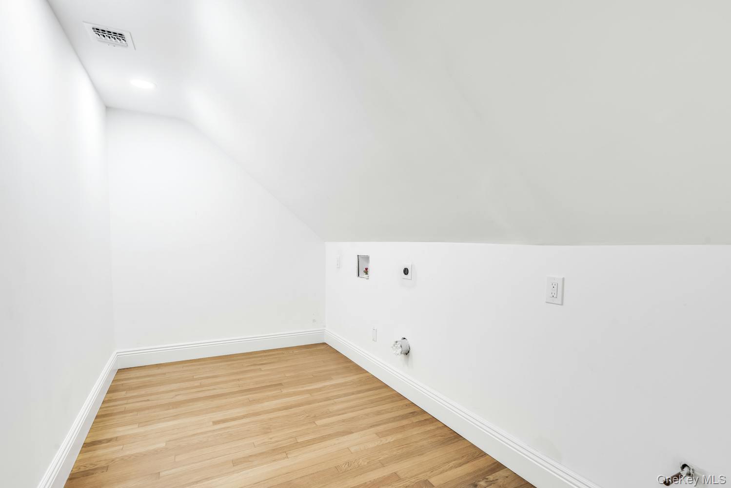 539 Split Rock Road Syosset, NY 11791 - Photo 31 of 40 Additional living space featuring baseboards, vaulted ceiling, light wood finished floors, and visible vents