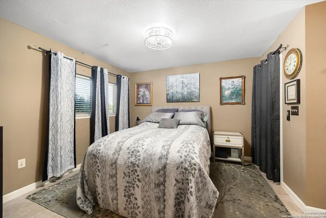 a spacious bedroom with a bed and a painting on the wall