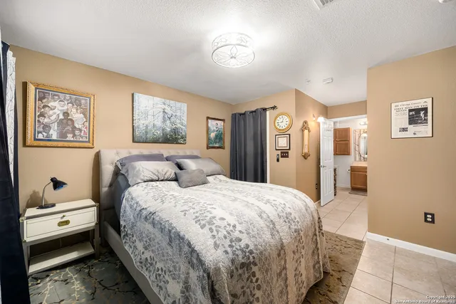 a bedroom with a large bed and a chandelier