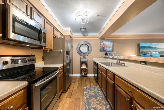 a kitchen with stainless steel appliances granite countertop a sink a stove and a refrigerator