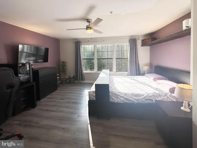 a large bedroom with a bed and large windows